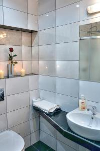 a white bathroom with a sink and a toilet at Pokoje BALDI Benelux in Skoczów