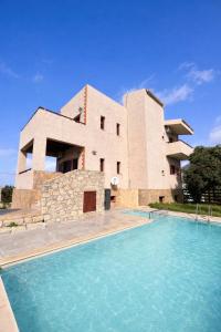 a house with a swimming pool in front of a building at Villa Evenos with private pool in Elafonisi