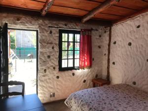 a bedroom with a bed in a room with a window at Cabaña Tío Ale MONOAMBIENTES in El Bolsón
