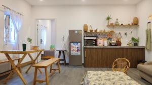 a kitchen and living room with a refrigerator and a table at Vevy House - Homestay in Town in Danang