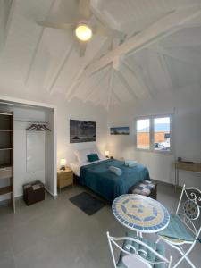 a bedroom with a bed and a table in it at Résidence Fleur de Café - Petite Terre in Deshaies