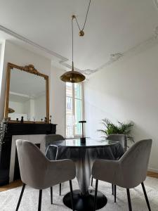 a dining room with a table and chairs and a mirror at La suite du parc 2 in Nancy