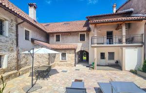 a patio with chairs and an umbrella in front of a building at Corte Maccarini - Appartamento Venezia - Dotato di corte interna privata in Mel