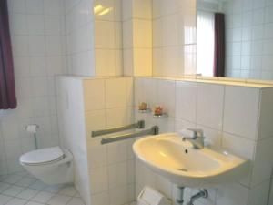 a white bathroom with a sink and a toilet at Ferienanlage Orther Reede, Fehmarn-Orth in Orth +7 photos