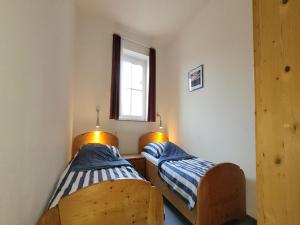 two beds in a small room with a window at Ferienanlage Orther Reede, Fehmarn-Orth in Orth
