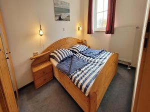 a bedroom with a wooden bed with two pillows at Ferienanlage Orther Reede, Fehmarn-Orth in Orth
