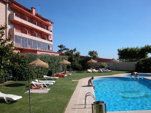 um grupo de pessoas sentadas ao redor de uma piscina em Hotel VIDA Playa Paxariñas em Portonovo