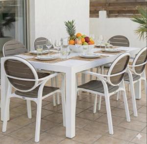 a white dining room table with four chairs at Fig Tree Beach Villa Five in Protaras