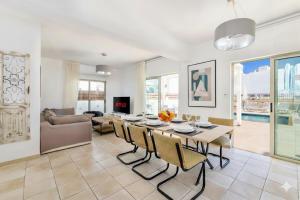 a living room with a table and chairs and a couch at Fig Tree Beach Villa Five in Protaras