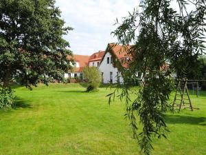 a large yard with a white house and trees at Appartements Post Hiddensee in Vitte in Vitte