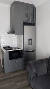 a kitchen with a stove and a refrigerator and a couch at B3 bnb House in Cape Town