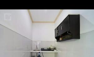 a kitchen with a black cabinet on the wall at Pondok tulamben in Karangasem