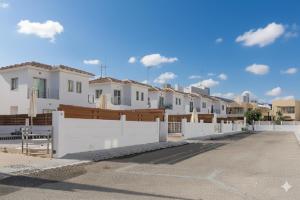 a row of houses behind a white fence at Fig Tree Beach Villa Five in Protaras