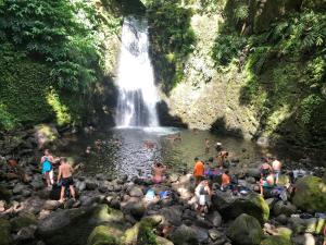 a group of people swimming in a waterfall at Xaminé in Água Retorta