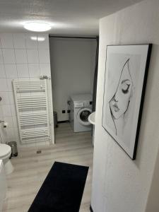 a bathroom with a picture of a woman on the wall at Ferienwohnung Sofie Marie in Oberhausen