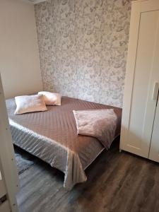 a bed with two pillows on it in a bedroom at Charmig stuga med havsutsikt in Karlskrona