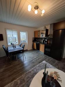 a living room with a table and a kitchen at Charmig stuga med havsutsikt in Karlskrona +37 photos