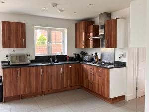 a kitchen with wooden cabinets and a microwave at Flexistay hub at Watford in Abbots Langley +16 photos