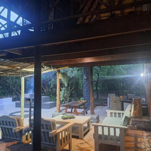 a patio with chairs and a table and a table at Kruger Tree Lodge in Marloth Park