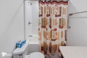 a bathroom with a shower curtain with a toilet at Soldotna-Kenai Peninsula House in Soldotna +13 photos