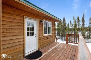 a wooden cabin with a door on a deck at Soldotna-Kenai Peninsula House in Soldotna