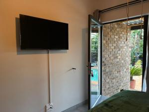 a flat screen tv on the wall of a bedroom at Luigi's Place in Pretoria