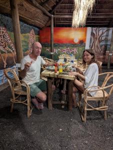 a man and a woman sitting at a table at Woodland villa in Arusha