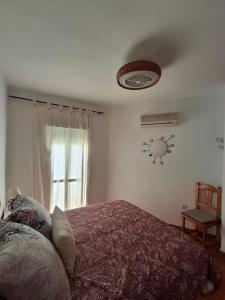 a bedroom with a bed and a clock on the wall at Duplex Barbados Aguamarga in Agua Amarga