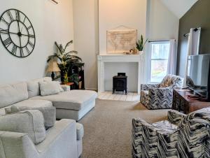 a living room with a couch and a clock on the wall at Family-Friendly Strasburg Escape | 50 Mile Views in Strasburg