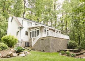 a white house with a porch and a balcony at Family-Friendly Strasburg Escape | 50 Mile Views in Strasburg