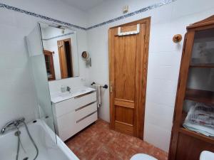 a bathroom with a sink and a wooden door at Duplex Barbados Aguamarga in Agua Amarga +20 photos