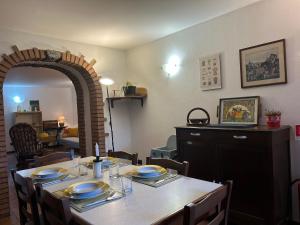 a dining room with a table with chairs and an arch at Al civico 7 Relax a due passi dal lago di Como in Oliveto Lario