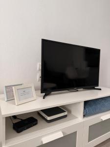 Ein Flachbildfernseher steht auf einem weißen Entertainment-Center. in der Unterkunft Las Damas Piso18 in Benidorm