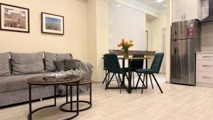 a living room with a couch and a table with chairs at Sweet Home Apart-Hotel in Yerevan