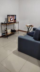 a living room with a couch and a flat screen tv at Refúgio das montanhas - Centro in Poços de Caldas