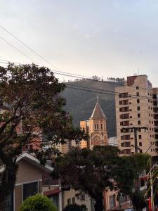 a building with a hill in the background of a city at Refúgio das montanhas - Centro in Poços de Caldas