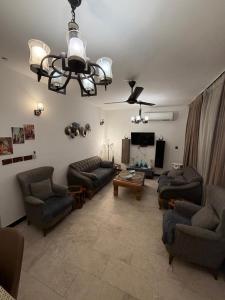 a living room with couches and a chandelier at اليرموك 4 شوارع in Baghdād