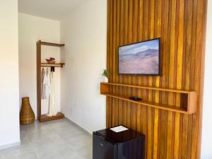 a living room with a tv on a wooden wall at Yahweh Hotel in São Miguel do Gostoso