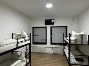 ein Zimmer mit drei Etagenbetten und zwei Fenstern in der Unterkunft Dottore Privatel in Hamburg