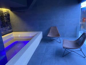 a room with a tub and two chairs in it at Apartmani G8 in Pale