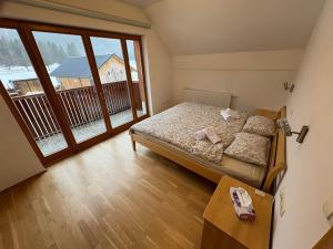a bedroom with a bed and a large window at Apartment Barbara with sauna in Gozd Martuljek