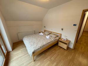 a small bedroom with a bed and a wooden floor at Apartment Barbara with sauna in Gozd Martuljek