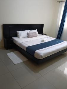 a bedroom with a large bed with a black headboard at Chesum's suites in Eldoret
