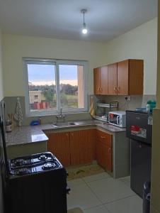 a kitchen with a stove top oven next to a window at Chesum's suites in Eldoret
