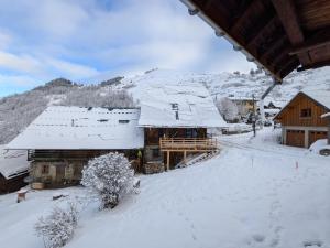 a winter view of a lodge with snow on the roofs at Grange de Marius - Authentique grange savoyarde in Albiez-Montrond