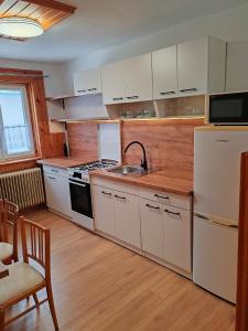 a kitchen with white cabinets and a white refrigerator at ZorHouse Ždiar in Ždiar