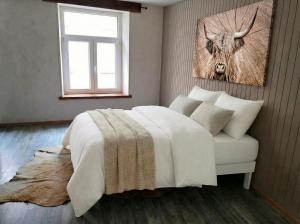 a bedroom with a bed and a picture of a deer at Golden Lion in Bouillon