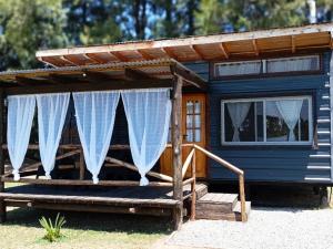 a blue house with awning and a porch with curtains at Cabañas Campos del Parana in San Pedro