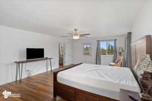 a white bedroom with a bed and a television at Soldotna-Kenai Peninsula House in Soldotna