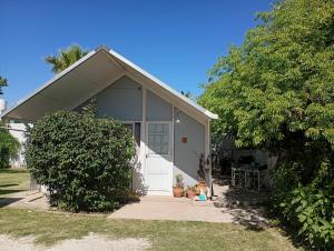 a house with a white door and a tree at Refugio Amaicha in Embalse